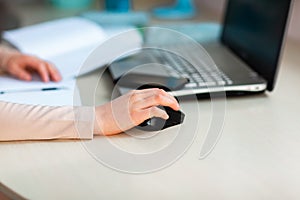 Close up of young school girl working at home in her room with a laptop and class notes studying in a virtual class. Distance