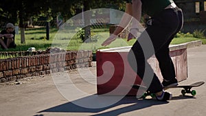 Close up of young skateboarder in casual clothes jumping over the ledge in summer day. Teenager is having bad fall