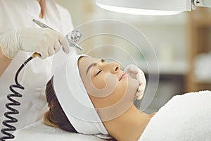 Woman getting oxygen therapy or jet peeling from cosmetologist