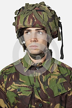 Close-up of young soldier against gray background