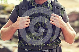 Close up of young soldier with backpack in forest
