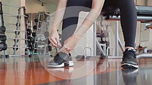 Close up of young sport woman tie up training shoe shoelace rope in fitness gym. Healthy and people lifestyle concept. Relaxation