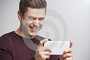 Close up of young white man taking selfie with a smartphone