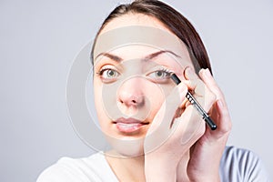 Close up Young Woman Applying Eyeliner Makeup