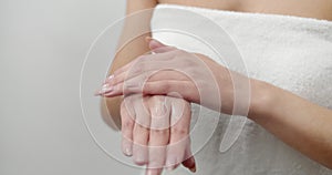 Close up of young woman applying moisturizer on hands