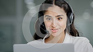 Close-up young woman assistant sales agent advisor hotline consultant answering incoming call using headset looking at