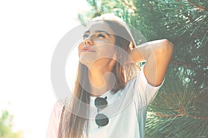 Close-up young woman with beautiful face features enjoying sun