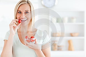 Close up of a young woman eating strawberries