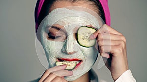 Close up young woman with a facial cream on her face. Funny girl, skin care. Model with a face mask and a towel on her
