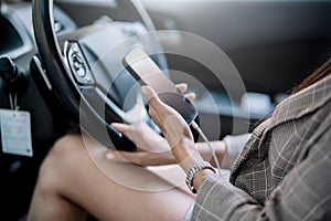 Close up of young woman hand using mobile phone in the car