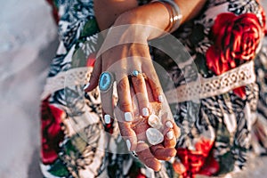 Close up of young woman hands with stylish gem stone rings and accessories