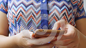 Close-up of young woman hands typing sms