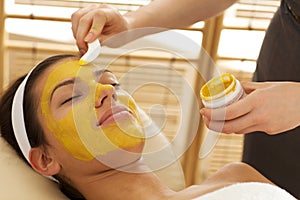 Close-up of young woman having facial mask in beauty parlor