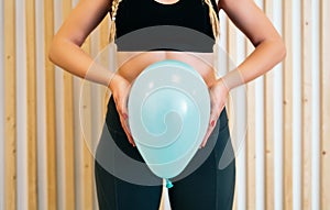 Close up of a young woman holding a balloon to explain the diaphragm zones, core and pelvic floor. Pelvic floor exercises photo