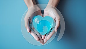 Close-up of a young woman holding a blue heart. Concept of love, finding the right partner, relationship and Valentine\'s Day