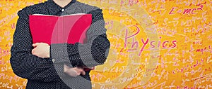 Woman holding a red book to chest. Education concept as student hugging a textbook, loving knowledge isolated over yellow wall