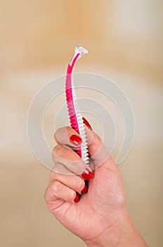 Close up of a young woman holding a shaver on her hand with a bath background