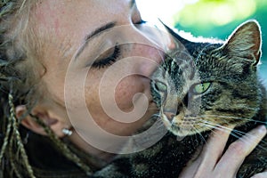 Close up on young woman kissing adorable cat