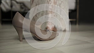 Close-up young woman legs. first wedding night. bride comes to a bed, removes shoes and lace dress