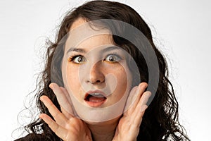 Close-up of young woman looking at camera, surprised