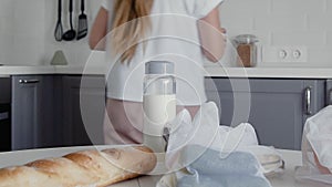 Close up of Young woman move bread, oatmeal, milk, vegetables from table to shelves. Zero waste home and eco bag. Eco