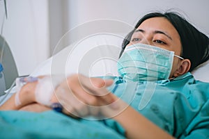 Close up young woman patient lay on bed in hospital with intravenous normal saline