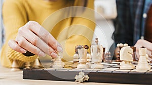 close up young woman playing chess board game. High quality photo