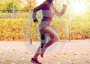 Close up of young woman running in autumn park