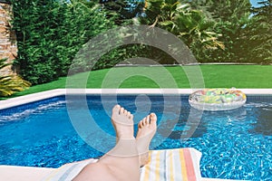 close-up of a young woman's bare feet on a swimming pool with a float. woman enjoying a summer holiday in a hotel