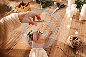 Close-up of a young woman's hands decorating candles for Christmas or New Year. Decorating items for the holiday and