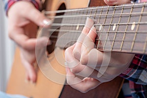 Close-up of a young woman`s hands playing guitar