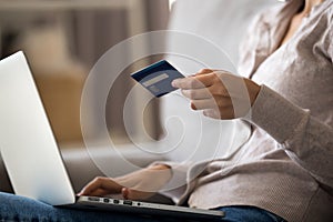 Close up young woman shopping online, paying with credit card