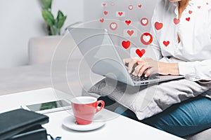 Close up young woman sit on couch at home and using laptop while use online dating application to greeting and talk with other for