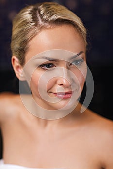 Close up of young woman sitting in bath towel