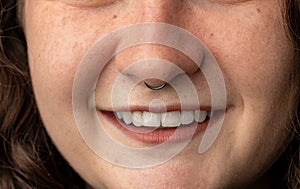 Close up of young woman smiling, with pierced nose