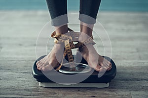 Close up. Young Woman Standing on Weigher on Floor
