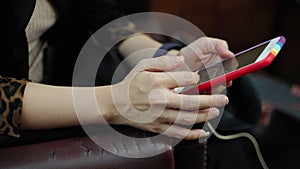 Close-up, a young woman in a suit sitting on a mobile phone surfing social media, internet of everything.