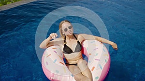 Close up of young woman sunbathing, swim with inflatable mattress donut