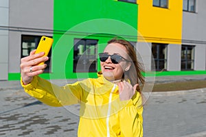 Close up of a young woman taking pictures with her smartphone in the street