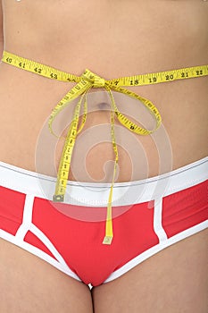 Close Up of a Young Woman With a Tape Measure Tied Around Her Waiste