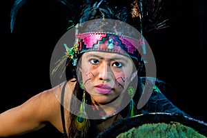 close up of young woman Teotihuacana, Xicalanca - Toltec in black background, with traditional dress dance with a trappings with