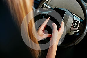 Close Up Of Young Woman Texting On Mobile Phone Whilst Driving Car