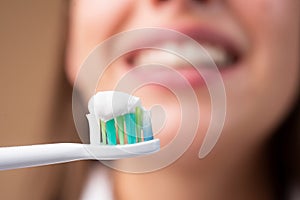 Close-up of young woman with toothbrush. Smiling young woman with healthy teeth holding a tooth brush. Human teeth