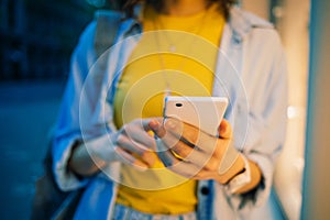 Close-up young woman typing in her mobile phone