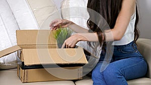 Close up young woman unpacking from a cardboard box