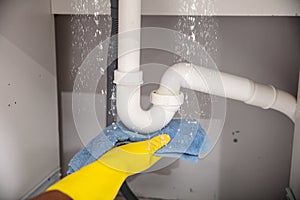 Woman Using Towel Under Leaking Sink Pipe