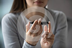 Close up young woman using lancet pen, measuring glucose level photo