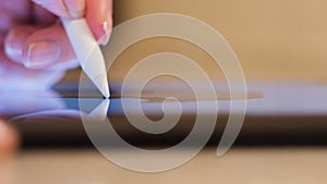 Close up of a young woman using a tablet for work, freelance. Concept. Female hand touching the screen of a digital pad