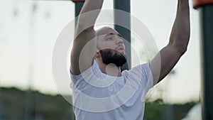 Close up of young Workout muscular man pulling elastic band outdoors.