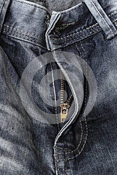Close-up zipper open on blue shabby jeans, denim texture, zipper jeans pants